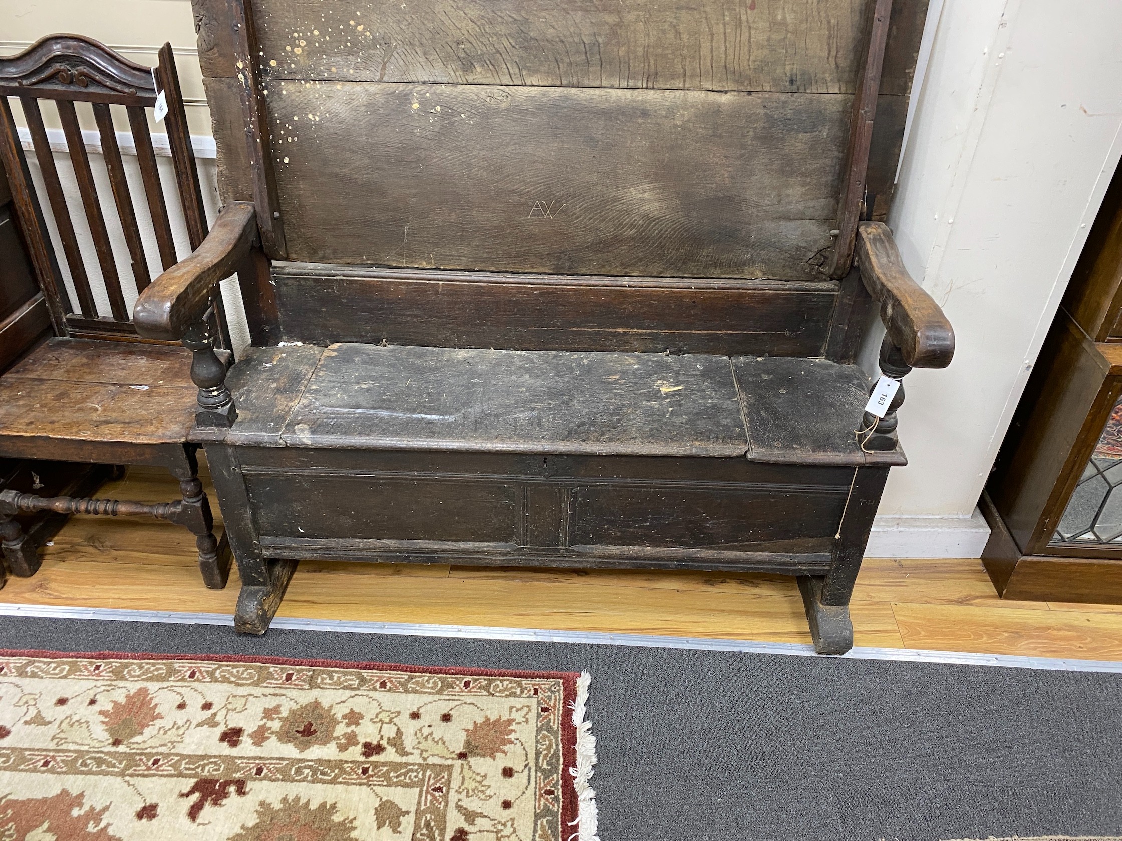 An 18th century oak monk's bench with hinged seat, length 132cm, depth 64cm, height closed 83cm
